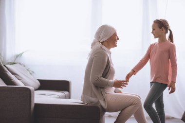 çocuk ve hasta büyükannesi atkı evde birbirine bakarak yan görünüm