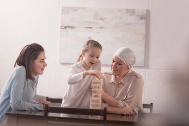 happy family of three generations playing with wooden blocks together, cancer concept  clipart