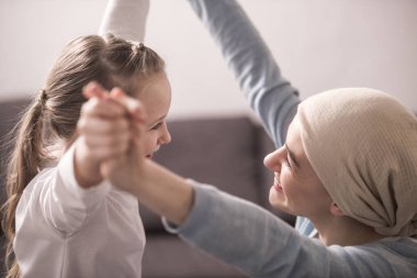 mutlu çocuk ve hasta anne elele ve birbirlerine gülümseyen atkı 