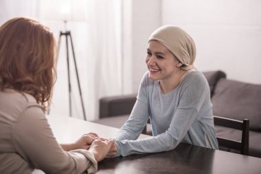 Anne ile el ele tutuşarak ve birbirine bakarak fuları hasta yetişkin kız