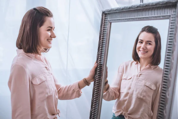 Bela Sorrindo Jovem Mulher Perto Espelho Olhando Para Reflexão — Fotografia de Stock