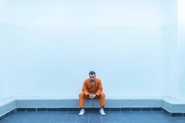 prisoner sitting on bench in prison room clipart