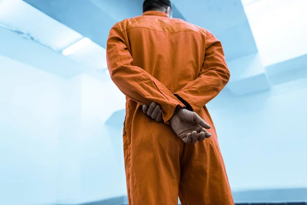 刑務所の独房で制服立っているオレンジの囚人の底面図 — ストック写真