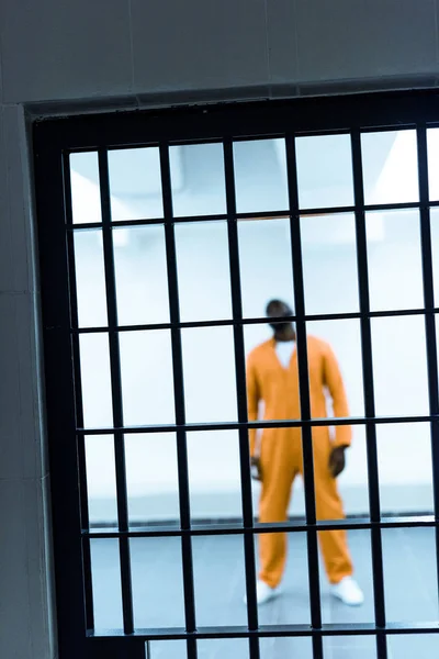 アフリカ系アメリカ人の囚人の刑務所バーの後ろに立っています — ストック写真