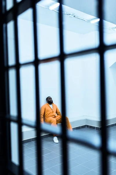 アフリカ系アメリカ人の囚人が刑務所の独房でベンチに座っています — ストック写真