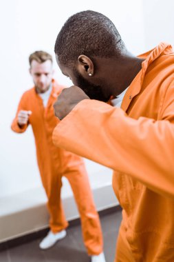 multiethnic prisoners fighting in prison cell clipart