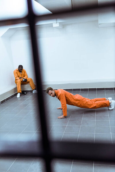 prisoner doing push-ups in prison cell