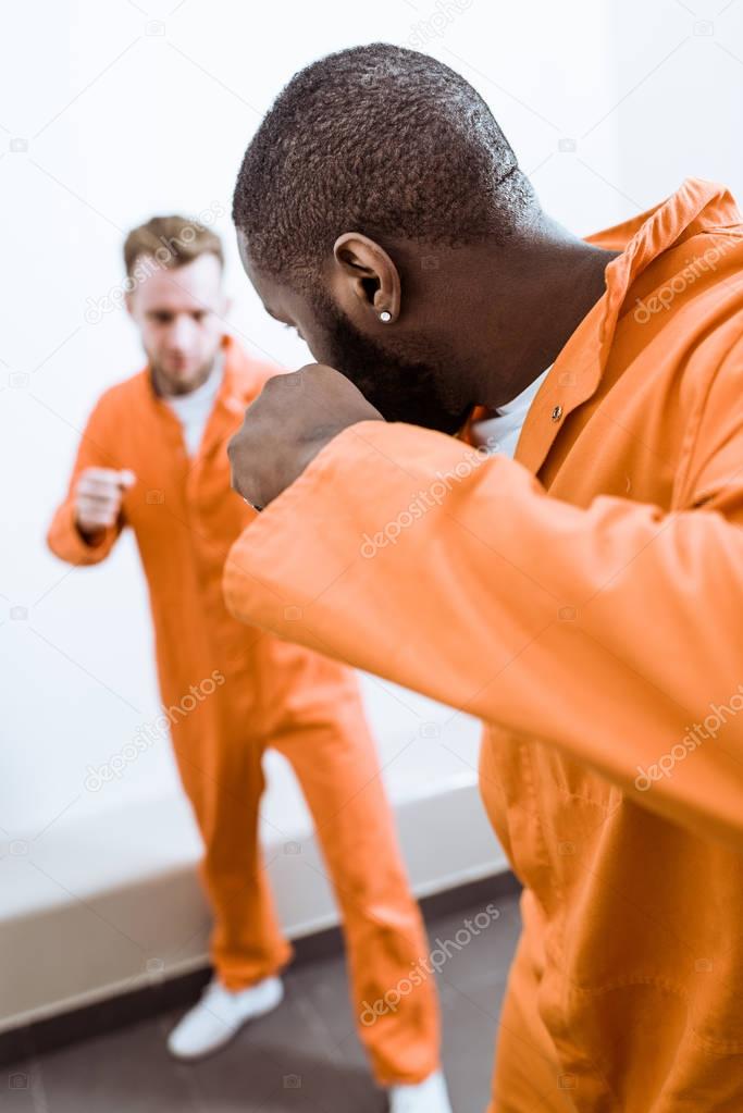 multiethnic prisoners fighting in prison cell
