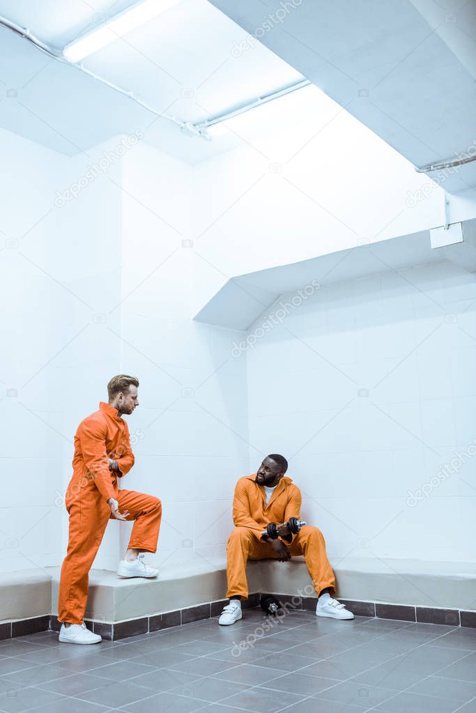 multiethnic prisoners in light modern prison cell