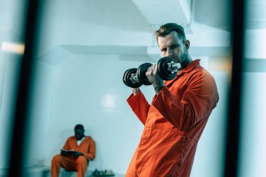 prisoner training with dumbbells in prison room clipart