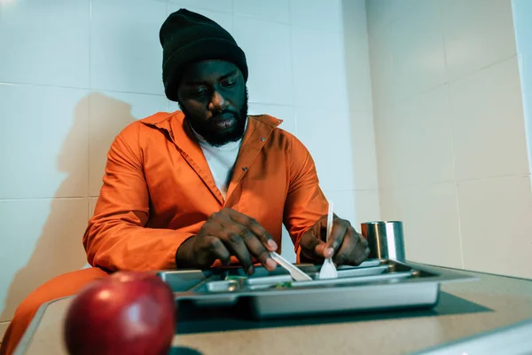 アフリカ系アメリカ人の受刑者が刑務所の独房で食べる — ストック写真
