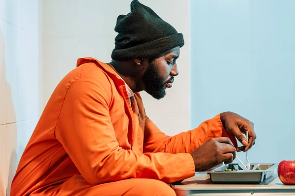 Seitenansicht Eines Afrikanisch Amerikanischen Gefangenen Beim Essen Einer Gefängniszelle — Stockfoto
