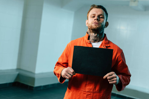 prisoner holding blackboard and looking at camera