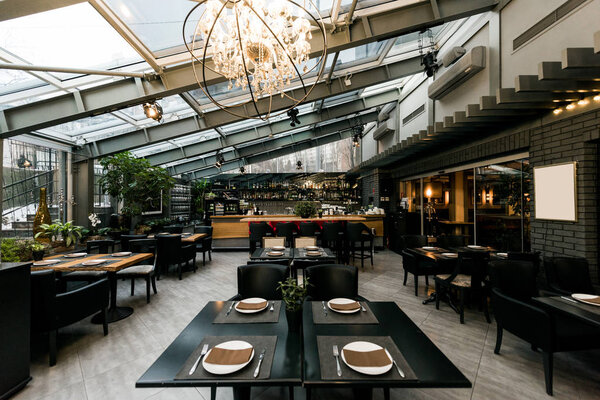 view of stylish empty cafe with arranged tables and chairs for visitors