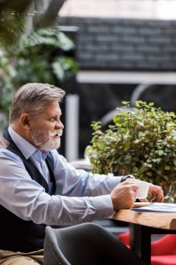 kafede kahve ile üst düzey sakallı adam yan görünüm