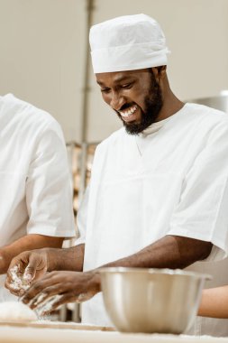 yakışıklı Afro-Amerikan baker üretim pişirme, pasta için hamur yoğurma