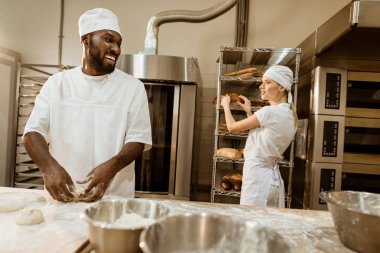 Afro-Amerikan baker üretim pişirme ve meslektaşı ile sohbet, hamur yoğurma