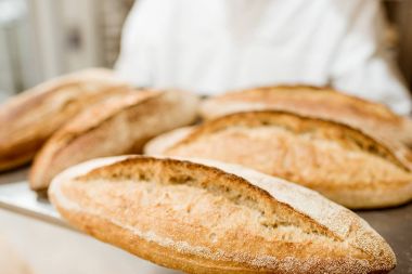 elinde tepsi ile taze somun ekmek fırıncı
