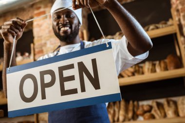 pasta mağaza açık işaret tutan mutlu Afro-Amerikan baker