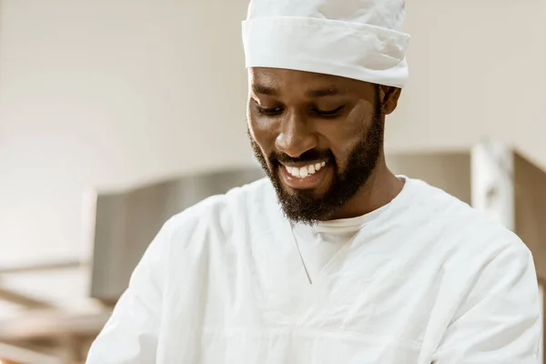 Yakışıklı Afro Amerikan Baker Şapkalı Üretim Pişirme Üzerinde Gülümseyen — Stok fotoğraf