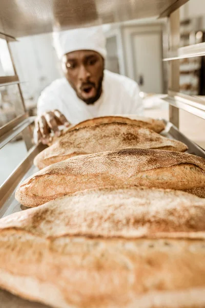 Excited African American Baker Looking Fresh Loaves Bread Baking Manufacture — Stock Photo, Image