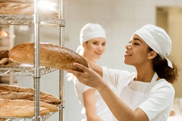 Female Baker Putting Fresh Bread Loaves Shelves Baking Manufacture While — Stock Photo, Image