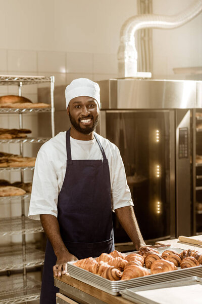 portrait of handsome african american baker at workplace on baking manufacture