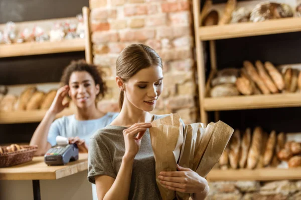 Kağıt Torbalarda Çeşitli Ekmek Pasta Mağaza Bırakarak Gülümseyen Genç Kadın — Stok fotoğraf