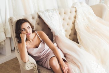 Düğün moda dükkanda kanepede oturan sıkılmış kadın