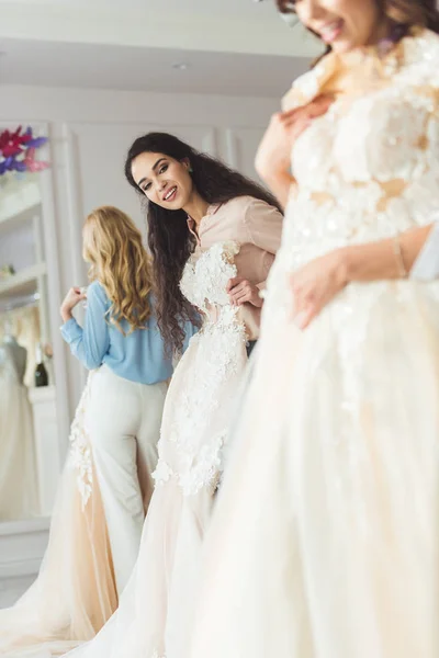 Junge Lächelnde Braut Und Brautjungfern Wählen Kleider Geschäft Für Hochzeitsmode — kostenloses Stockfoto