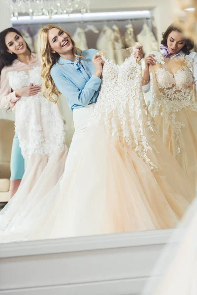 Счастливая Невеста Подружки Невесты Примеряют Платья Через Зеркало Свадебном Магазине — Бесплатное стоковое фото
