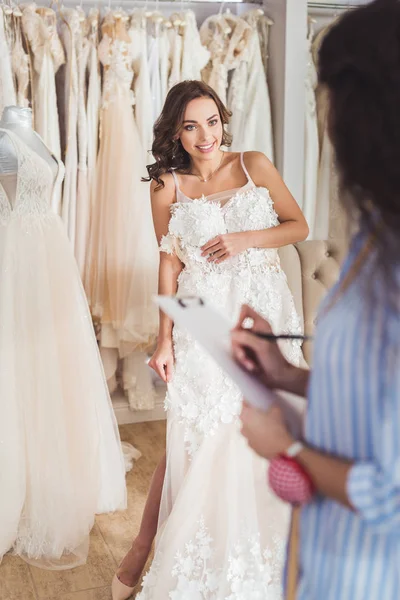 Schöne Braut Und Schneiderin Probieren Kleid Hochzeitsatelier — kostenloses Stockfoto