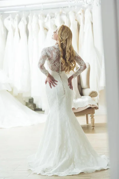 Young bride in lace dress in wedding atelier
