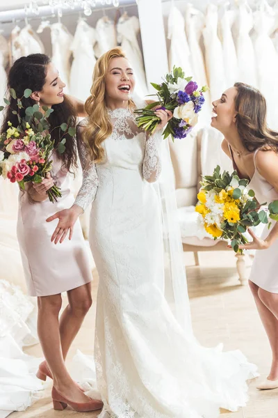 Junge Lächelnde Braut Und Brautjungfern Mit Blumensträußen Geschäft Für Hochzeitsmode — kostenloses Stockfoto