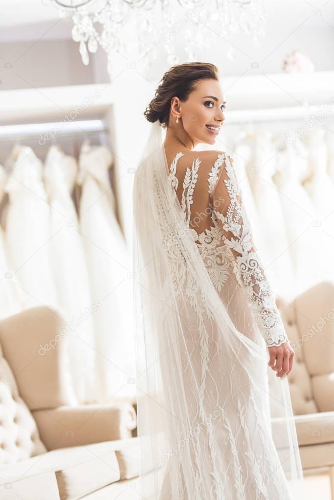 Young bride in white dress in wedding atelier