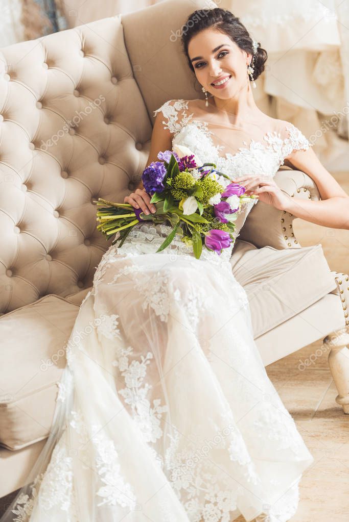 Attractive bride holding bouquet in wedding fashion shop