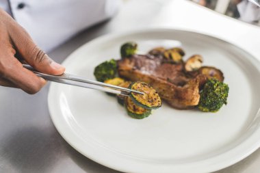 Afrika kökenli Amerikalı şef plaka restoran mutfak at kabak parçası koyarak görüntü kırpılmış