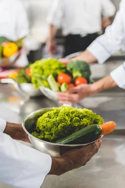 Abgeschnittenes Bild Multiethnischer Köche Die Schüsseln Mit Gemüse Der Restaurantküche — Stockfoto
