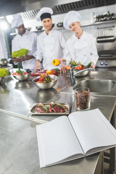 Chefs Multiculturais Cozinha Restaurante Com Livro Receitas Primeiro Plano — Fotografia de Stock