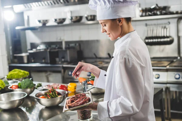 Attractive Chef Adding Herbs Raw Steaks Restaurant Kitchen — Stock Photo, Image