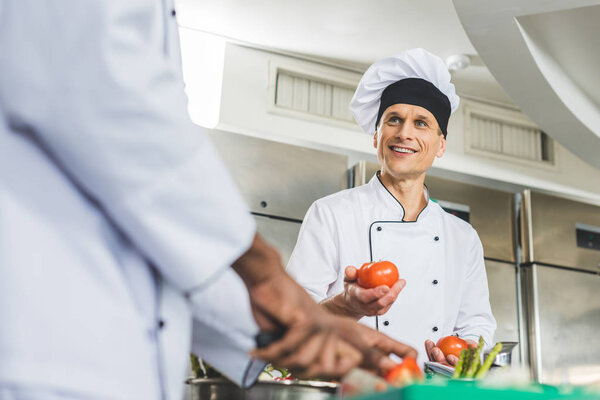 multicultural chefs preparing salad at restaurant kitchen