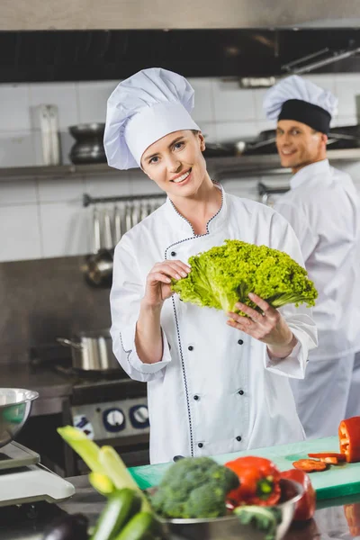 Uśmiechający Się Kucharzy Patrząc Kamery Restauracji Kitchen — Zdjęcie stockowe