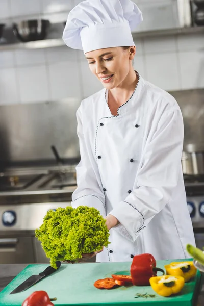 Atraktivní Šéfkuchař Drží Salát Listy Restauraci Kitchen — Stock fotografie