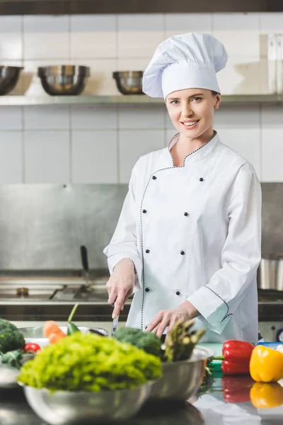 Aantrekkelijke Chef Kok Snijden Groenten Bij Restaurant Keuken Camera Kijken — Stockfoto