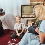Selectieve aandacht van ouders kijken van schattige kinderen spelen thuis, 50s stijl