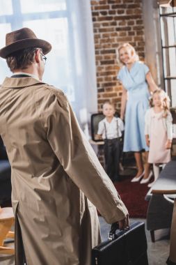 back view of father with briefcase coming home and looking at happy family, 1950s style clipart