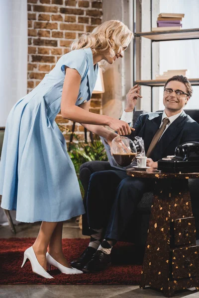 Улыбающаяся Женщина Наливает Кофе Счастливому Мужу Костюме Очках Сидящим Кресле — стоковое фото