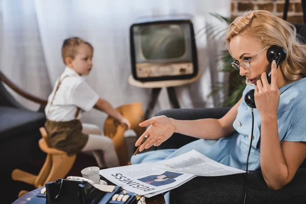 Žena Brýlích Čtení Obchodní Noviny Mluví Vintage Telefonicky Zatímco Malý — Stock fotografie