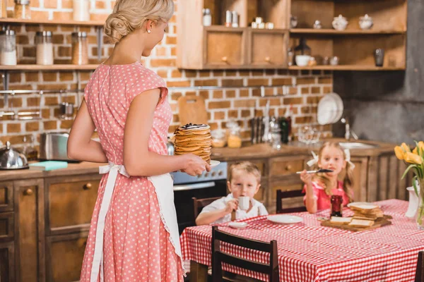Adorable Little Children Sitting Table Looking Mother Holding Delicious Pancakes — Stock Photo, Image