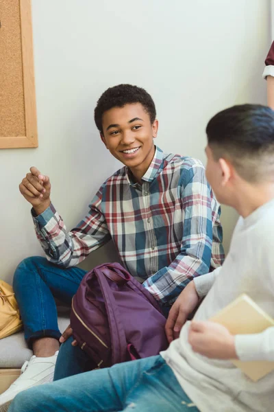 Lachende Afro Amerikaanse Middelbare Schoolstudent Praten Met Klasgenoot Tijdens School — Stockfoto